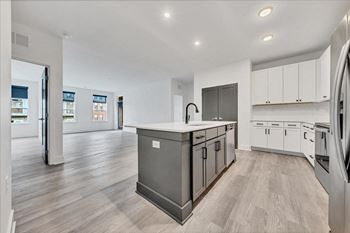 A modern kitchen with a large island and stainless steel appliances.